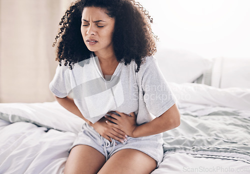 Image of Abdomen pain, period and black woman in bed with abdominal cramps, menstruation and stomach ache. Health, medical emergency and girl with digestion problem, pms crisis and endometriosis in bedroom