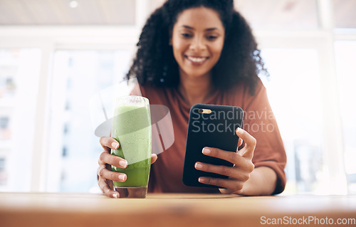 Image of Hands, smoothie and smartphone with a black woman in the kitchen of her home for health, weight loss or nutrition. Mobile, glass and wellness with a female posting a status update on social media