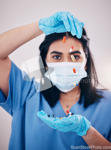 Image of Woman, doctor and hands with face mask and pills for healthcare or antibiotics against a studio background. Female medical nurse expert with latex gloves, tablets or prescription medication for pain