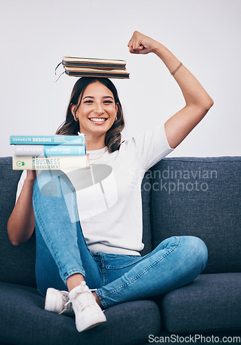 Image of Portrait, education and success with a student woman flexing her bicep while sitting on a sofa in her home. University, books and balance with an attractive young female pupil feeling confident