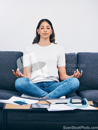 Image of Zen, meditation and Indian woman in a living room with yoga to relax from book learning. Sofa, home and female student meditate on a couch doing wellness exercise in a house with education notebook