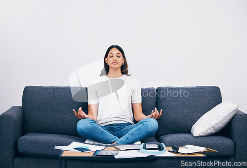 Image of Studying, meditation and Indian woman in a living room with zen to relax from book learning. Sofa, home and female student meditate on a couch doing yoga for wellness in a house with education book