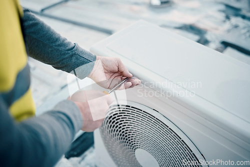 Image of Hands, air conditioner and maintenance with a man construction worker on a rooftop to install a cooling system. Engineer, hvac and ac repair with a male handyman servicing a building closeup