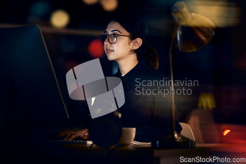 Image of Serious, woman and night business on computer for planning, research or strategy in office. Female working overtime on desktop technology, online or network of internet analytics, seo vision or focus