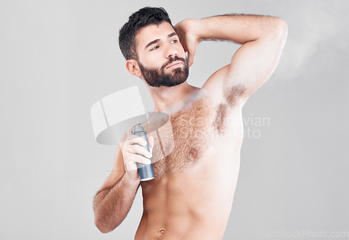 Image of Deodorant, beauty spray and man in studio for hygiene, fresh scent or sweat control. Male model spraying armpit for body odor, smell and cleaning cosmetics, shower product and skincare on background