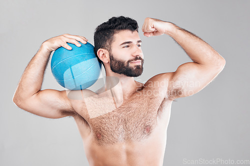 Image of Sport, fitness and man with ball flexing arm, topless and isolated on grey background. Exercise, motivation and sports goals, strong bodybuilder with workout mindset for training in studio with smile