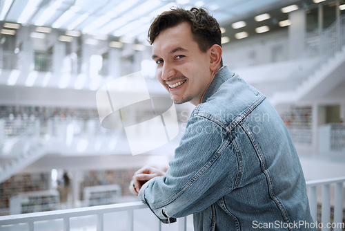 Image of College, education and portrait of a man in the library for learning, research and reading. Smile, future goals and happy student at university for studying, knowledge and scholarship for school