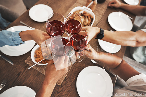 Image of Top view, hands and toast with red wine at dinner table for new year celebration in home. Party, cheers and group of friends, men and woman with alcohol or beverage to celebrate with delicious food.