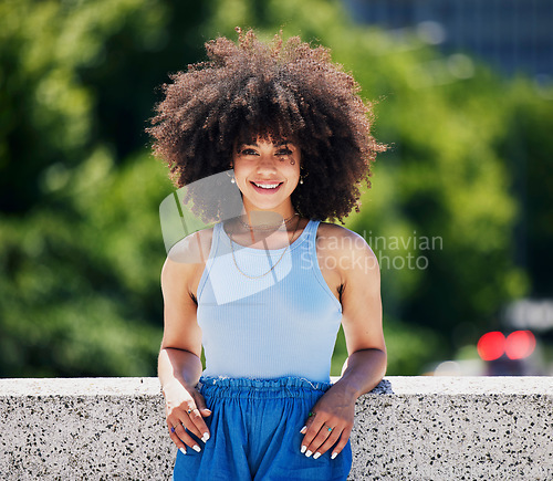 Image of Portrait, fashion and city bridge with a black woman outdoor, looking relaxed during a summer day. Street, style or urban and an attractive young female posing outside with an afro hairstyle