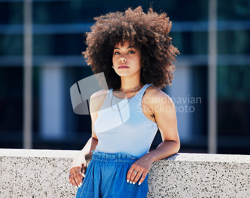 Image of Portrait, fashion and attitude with a black woman in the city, outdoor on a bridge during a summer day. Street, style or urban and an attractive young female posing outside with an afro hairstyle