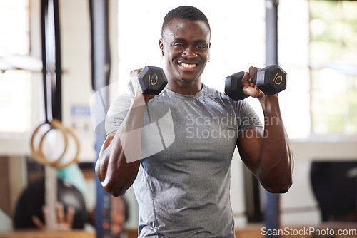 Image of Fitness, weights and portrait of a black man lifting for muscle, training and power in the gym. Smile, strong and African athlete doing a workout, exercise or sports for body building and cardio