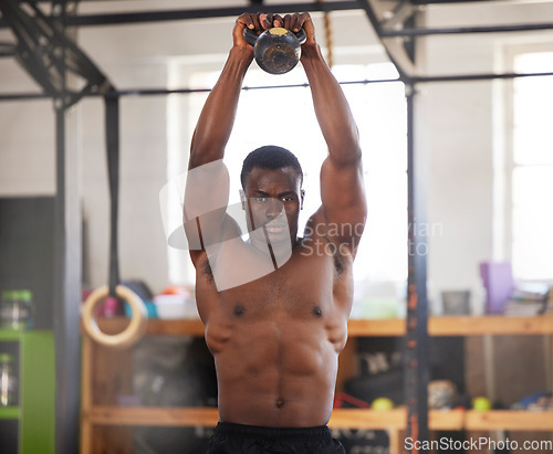 Image of Black man, bodybuilder and kettlebell for fitness in gym, arm muscle training, portrait and weightlifting exercise. Biceps, strong and bodybuilding, focus and serious with commitment to workout