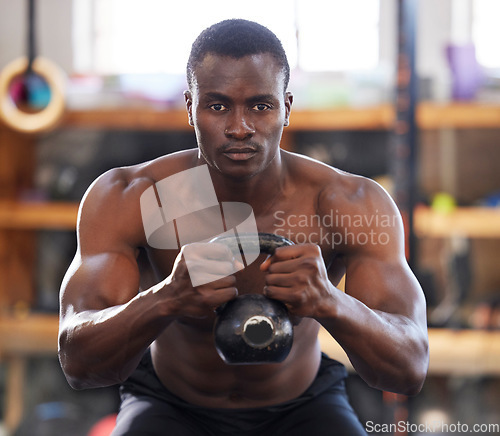 Image of Black man with kettlebell in gym, fitness and focus with arm muscle training, bodybuilder and weightlifting exercise. Biceps, strong and bodybuilding, power and serious with commitment to workout