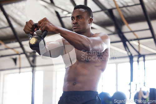 Image of Black man with kettlebell in gym, fitness and power with arm muscle training, bodybuilder and weightlifting exercise. Biceps, strong and bodybuilding, focus and serious with commitment to workout