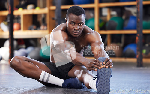 Image of Stretching, training and portrait of black man in gym for sports, workout and performance. Wellness, exercise and fitness with athlete and warm up legs on floor for cardio, endurance and energy