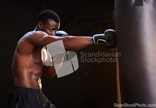 Image of Boxing, fitness and black man isolated on a dark background or gym training and bodybuilder fist impact. Strong, power and focus of boxer, athlete or sports person with exercise, workout in mma gear