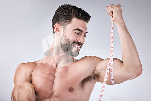 Image of Fitness, body and strong man with tape measure for biceps for exercise goals on studio background. Happy bodybuilder measuring arm for training, workout or muscle growth progress, results or target