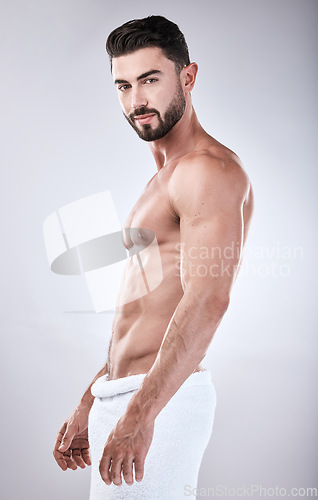 Image of Muscular man, standing and smile with towel for clean hygiene, wash or skincare isolated on gray studio background. Portrait of attractive male model smiling for fit body, cosmetics or fresh grooming