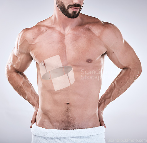 Image of Fitness, abs or body of a man cleaning for wellness, luxury skincare or self love on studio background. Spa, sexy chest or topless male model with a towel after washing for health and natural hygiene