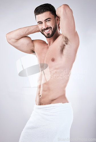 Image of Muscular man, portrait smile and towel flexing for clean hygiene, wash or skincare isolated on gray studio background. Happy attractive male model smiling for fit body, cosmetics or fresh grooming
