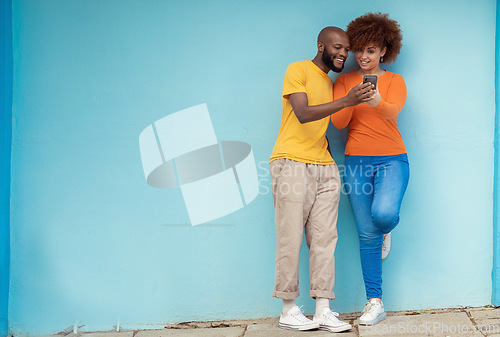 Image of Friends, wall and smartphone for social media, outdoor and connection in street, mockup and happiness. Black man, casual woman and cellphone for communication, share photos and smile in city or town