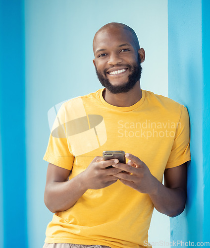 Image of Black man, portrait or phone typing on blue background, mockup or wall mock up on social media, internet app or blogging. Smile, happy person or fashion clothes on mobile technology for trendy ideas