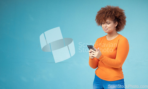 Image of Woman, cellphone connection and mockup on blue background for social media, website and network. Young female typing on mobile technology in studio for online advertising, marketing app and contact