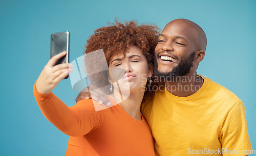 Image of Couple, bonding or funny faces selfie on blue background, isolated mockup or wall mock up on social media. Comic, goofy or silly man and woman on photography technology in interracial profile picture