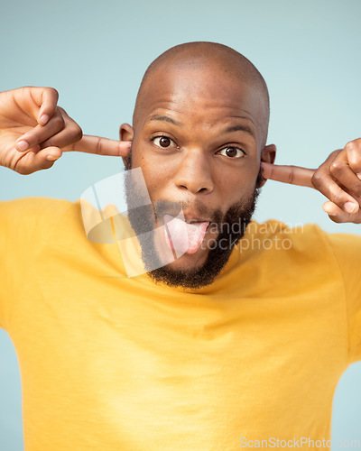 Image of Comic, playful and portrait of a black man with a funny face isolated on a blue background in studio. Crazy, comedy and silly African person with tongue out for expression, goofy and playing