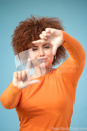 Image of Hands, frame and portrait of black woman on blue background for profile picture. Face, female and finger framing for perspective, selfie and vision of aesthetic focus, idea and photography in studio