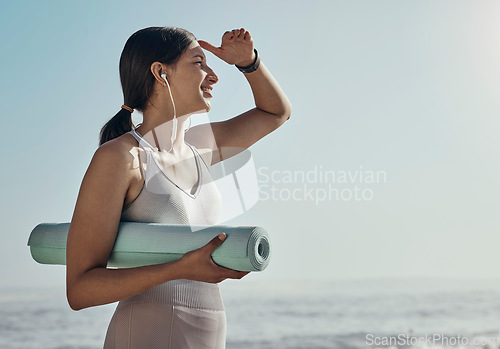 Image of Fitness, peace and yoga mat by woman at the beach for exercise, balance and cardio on blue sky background. Meditation, training and girl relax at the ocean for wellness, peace and zen at the sea