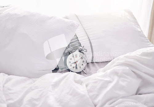 Image of Time, waking up and alarm clock on a bed with no people for punctual, sleeping and hour management. Empty, bedroom and vintage timer for routine, sleep and rest schedule, snooze and resting on mockup