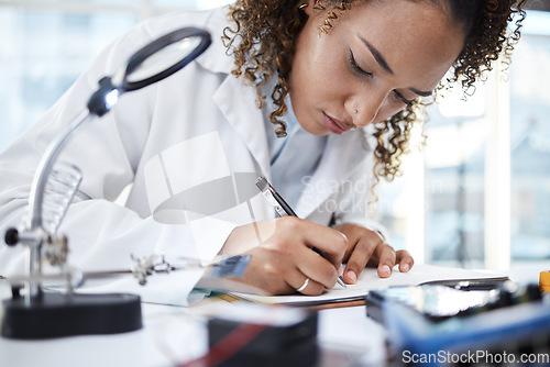 Image of Science, research and writing with a black woman doctor working in a laboratory for innovation or breakthrough. Notebook, data and checklist with a female scientist at work on a report in a lab