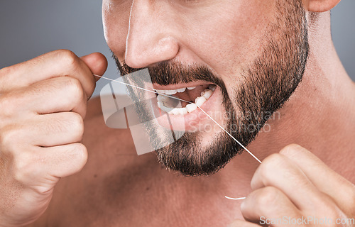 Image of Mouth floss, tooth and man in studio for beauty, healthy body care and hygiene on background. Closeup of male, teeth flossing and cleaning face for facial wellness, fresh breath and dental cosmetics