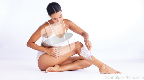 Image of Skincare, legs and shaving, woman in studio sitting with hand on leg and razor for hair removal product placement. Smooth shave, skin and beauty, body care mockup, girl isolated on white background.