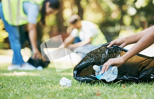 Image of Volunteer hands, cleaning up and trash bag for pollution, carbon footprint and eco friendly in park. Closeup, zoom and plastic collection outdoor, sustainability and charity service for environment