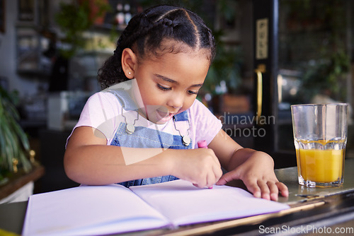 Image of Little girl, book and color at cafe, creative and drawing with crayons for family day or relax in learning and art. Young kid, growth and writing in education for creativity at coffee shop startup