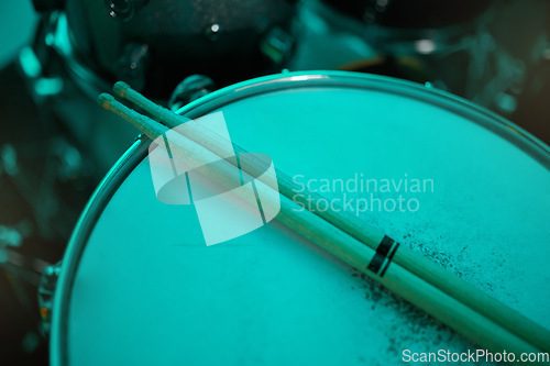 Image of Top view of sticks on drums instrument in music studio, production or live band in neon green light. Background closeup of drum kit of musician, concert and sound performance to record at talent show