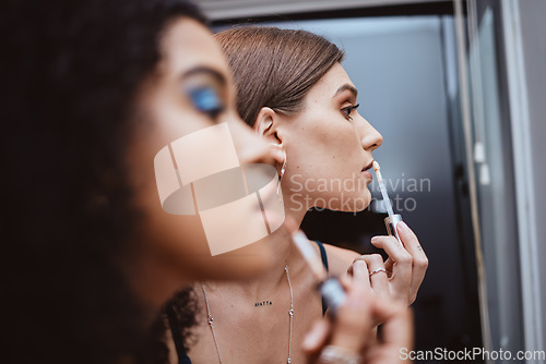 Image of Women, friends and makeup at mirror in bathroom for beauty, diversity or cosmetics in night together. Black woman, girl and model with lipstick, dark aesthetic and creativity for cosmetic application