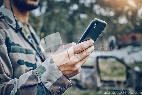 Image of Military soldier, mobile phone and communication while outdoor for connection, safety and security. Army person with a smartphone for social media, contact or chat on a field, boot camp or at war
