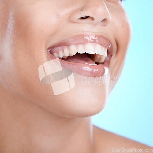 Image of Teeth, dental and woman with face and smile, beauty and oral healthcare, clean mouth with fresh breath in studio. Veneers, orthodontics and lips with skin, glow and cosmetic care on blue background