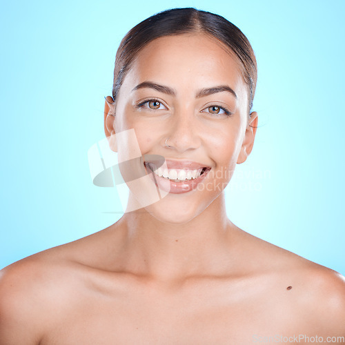 Image of Skincare, happy and portrait of woman in studio for makeup, wellness or grooming on blue background. Face, beauty and girl skin model relax with luxury, glamour and cosmetic treatment while isolated