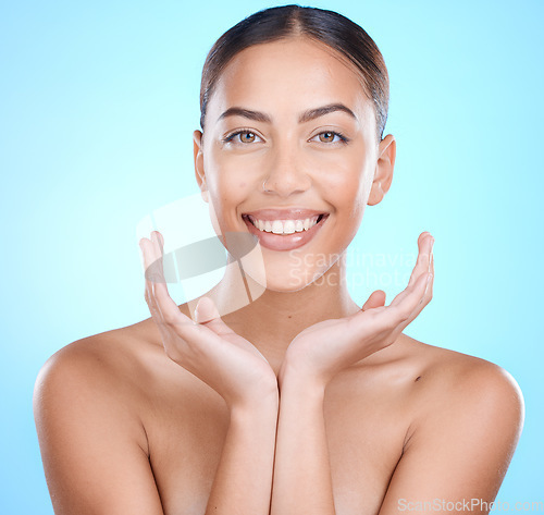 Image of Beauty, skincare and portrait of woman with smile on blue background for wellness, cosmetics and self care. Dermatology, luxury spa and hand and face of girl for makeup, glow and facial treatment