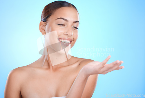 Image of Skincare beauty, woman and hand with mockup space for natural cosmetics product by blue background. Happy model, skin glow and aesthetic with makeup for cosmetic mock up in studio with excited smile