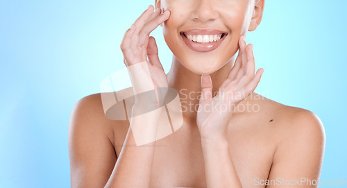 Image of Hand, face and touching skin with a model woman in studio on a blue background for beauty or skincare. Hands, touch and facial with a young female indoor to promote an antiaging cosmetic product
