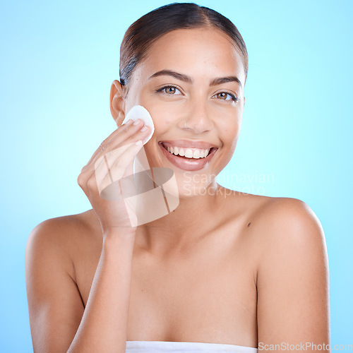 Image of Skincare, portrait and woman with cotton in studio for cleaning, wellness and toner on blue background. Face, beauty and makeup, pad and girl model relax with skin, grooming and hygiene isolated