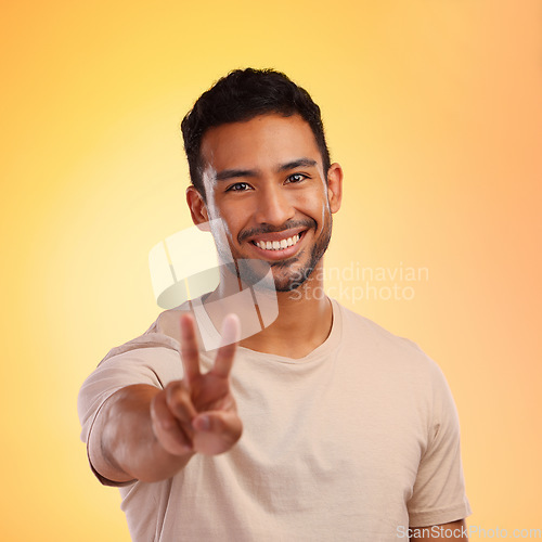 Image of Portrait, hands and man with peace sign in studio isolated on a yellow background. Face, fashion and hand gesture, v symbol or emoji of happy young male model in stylish, designer and cool clothing.