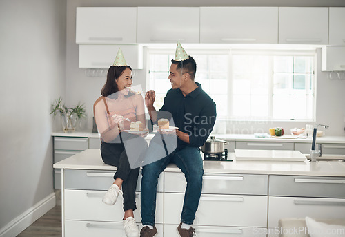 Image of Cake, birthday and couple in a kitchen for celebration, happy and bonding in their home, smile and laughing. Party, people and man with woman on a counter for eating, fun and celebrating in Japan