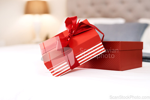 Image of Present, love gift and bedroom with no people with celebration box for valentines day. Red gifts, presents and bed in a house with surprise, celebrating and birthday package with ribbon and zoom