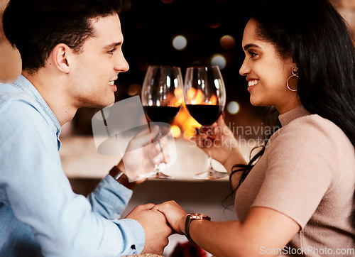 Image of Date night, wine and fire with couple holding hands at restaurant with love and care. Anniversary celebration, valentines day and happiness of young people together with alcohol in glass with cheers